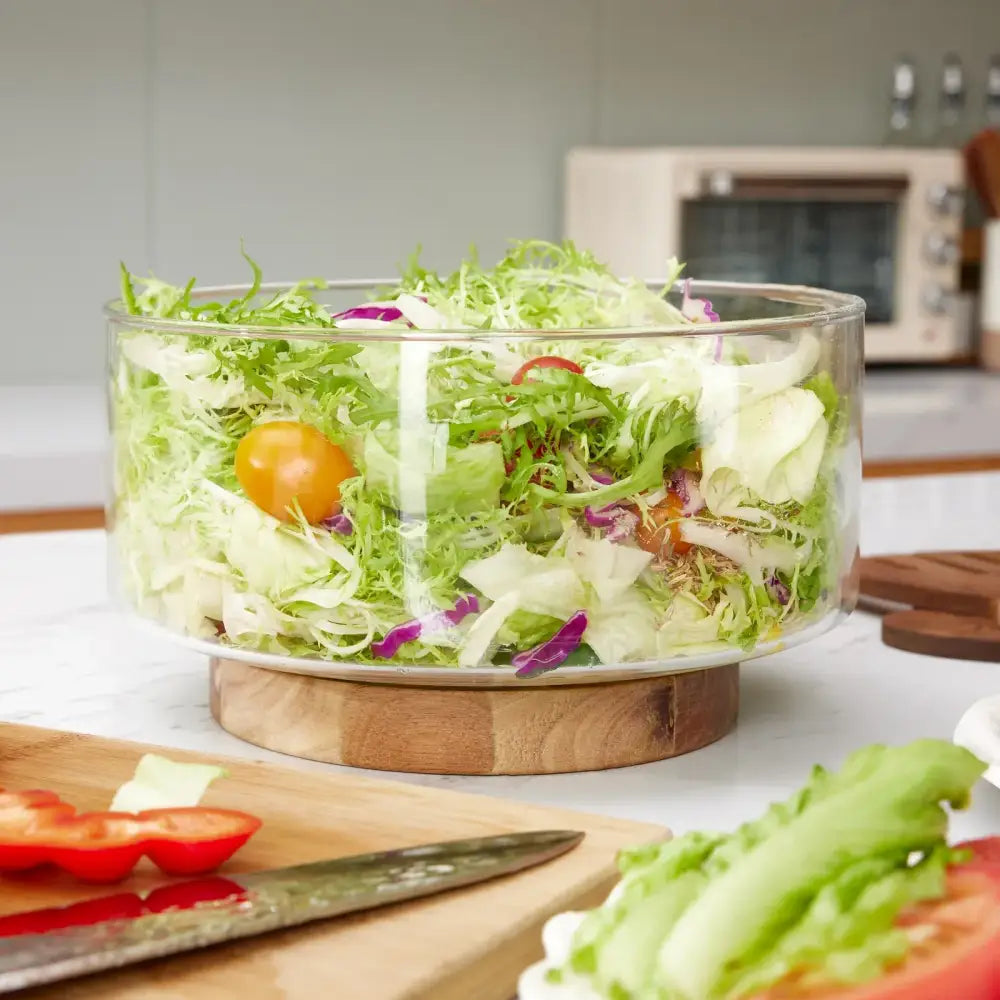 Clear glass fruit bowl with wooden base filled with fresh salad greens from decorbites creative glass collection