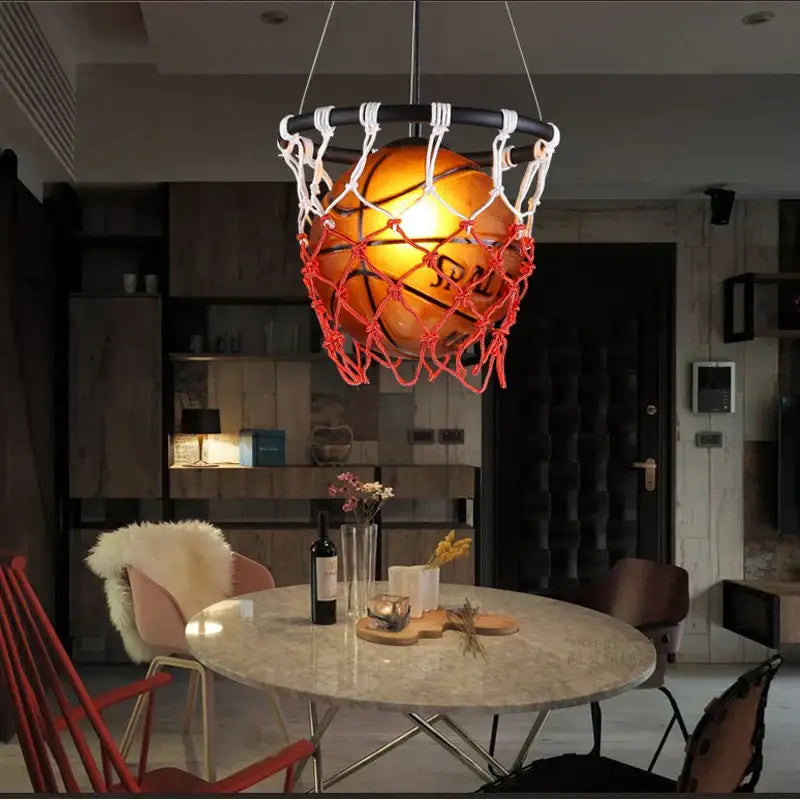 Creative orange basketball pendant light with warm tones suspended in a red and white net decorbites basketball pendant