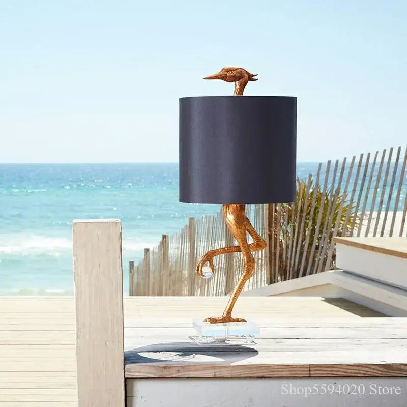 Golden bird-shaped table lamp with black shade and clear glass base for bedroom decor by decorbites creative ostrich table