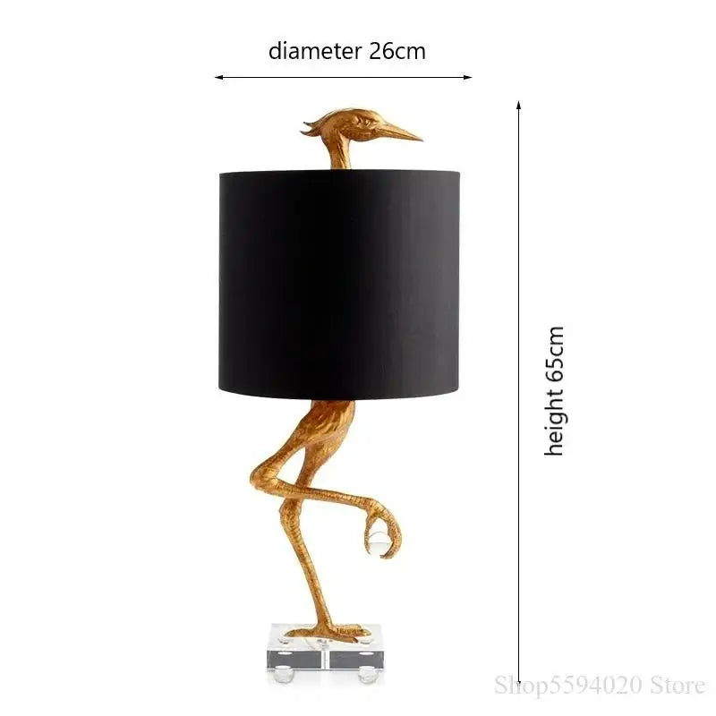 Golden bird-shaped table lamp with black cylindrical shade and clear acrylic base from decorbites creative ostrich table collection