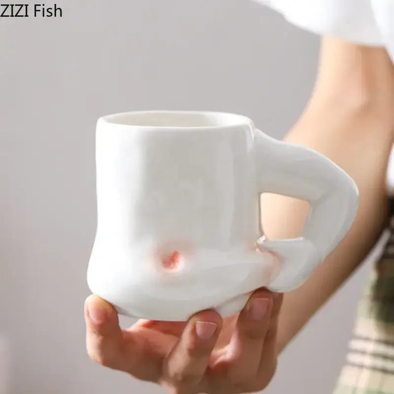 White ceramic creative pinch belly mug with organic hand handle and subtle pinkish glaze accents for dining room use
