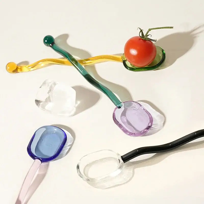 A creative purple and green hand-blown glass spoon dessert set with a wavy handle for ice cream and coffee