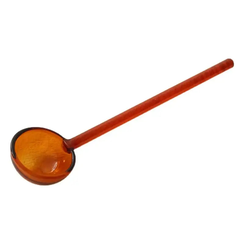 Translucent amber glass ladle with smooth rounded bowl and long handle in creative purple and green glass spoon dessert set for kitchen dining