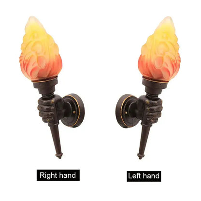 Pair of bronze wall lamps with sculpted hand grips and yellow to orange flame glass shades by decorbites creative torch