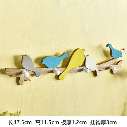 Wooden green and beige coat rack with five painted birds in gray blue and yellow and white spherical hooks decorbites birds coat rack