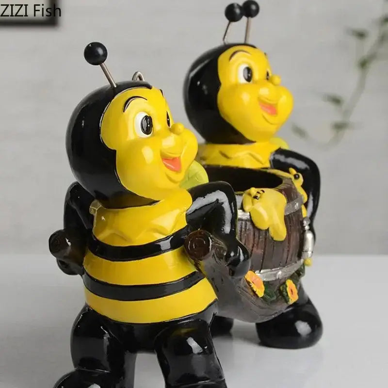 Creative yellow and black bee resin vase featuring glossy resin bee figurines with one holding a miniature barrel for plants
