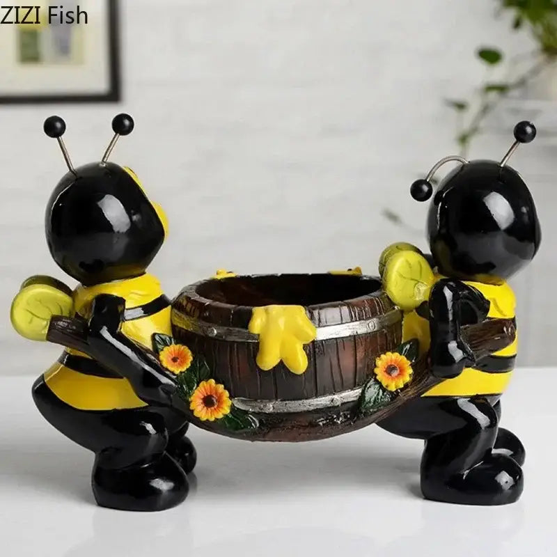 Creative yellow and black bee resin vase featuring two glossy bee figurines carrying a rustic wooden planter with sunflowers