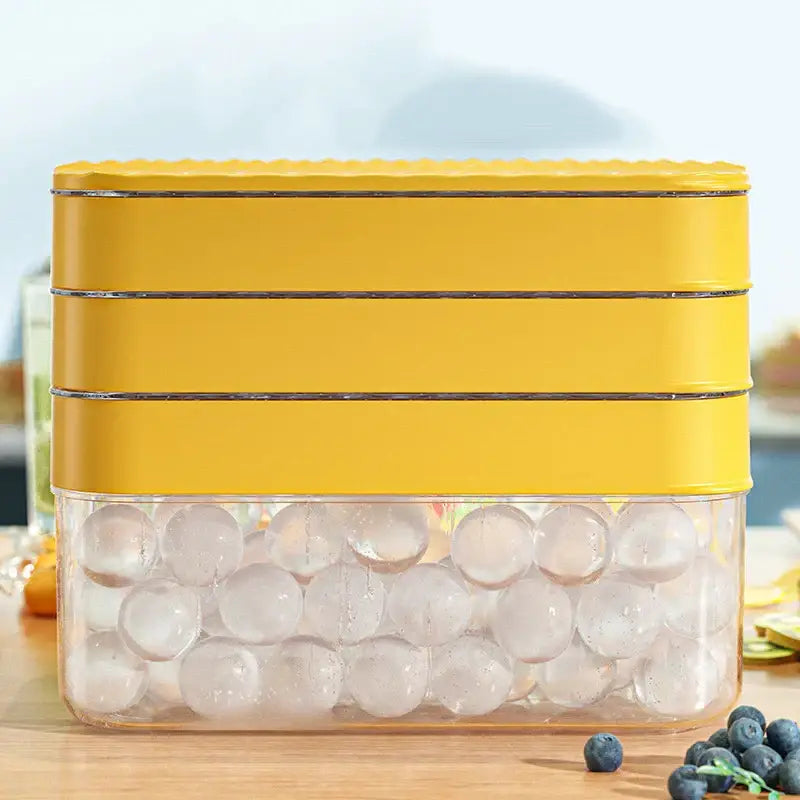 Yellow silicone ice mould tray with clear bottom compartment filled with ice balls for kitchen drink cooling