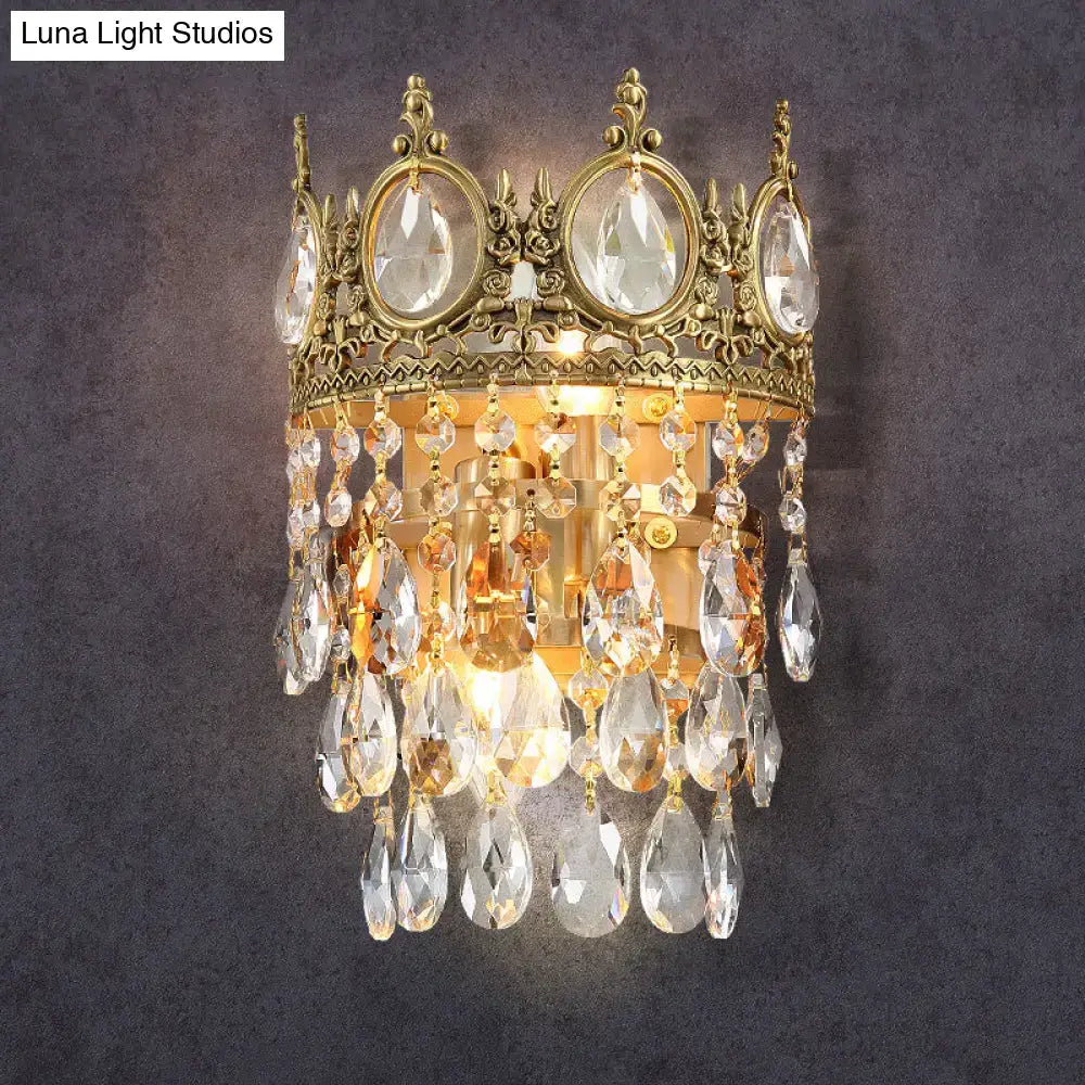 Gold-toned crown shaped round wall mounted lighting with clear crystal prisms and amber teardrop crystals for bedroom use