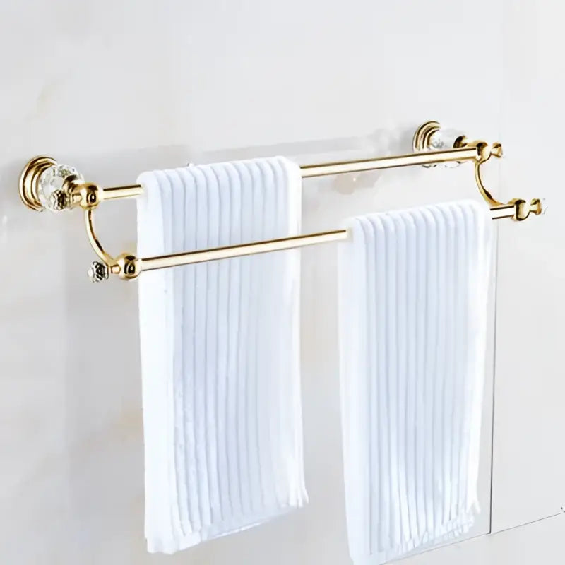 Gold-finished crystal bathroom accessories double towel rack with crystal accents holding white ribbed towels decorbites brass