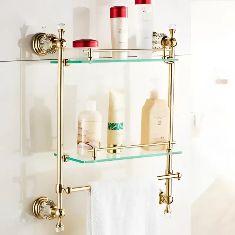 Gold-toned crystal bathroom accessories set featuring brass shelf with clear glass and ornate crystal-accented brackets
