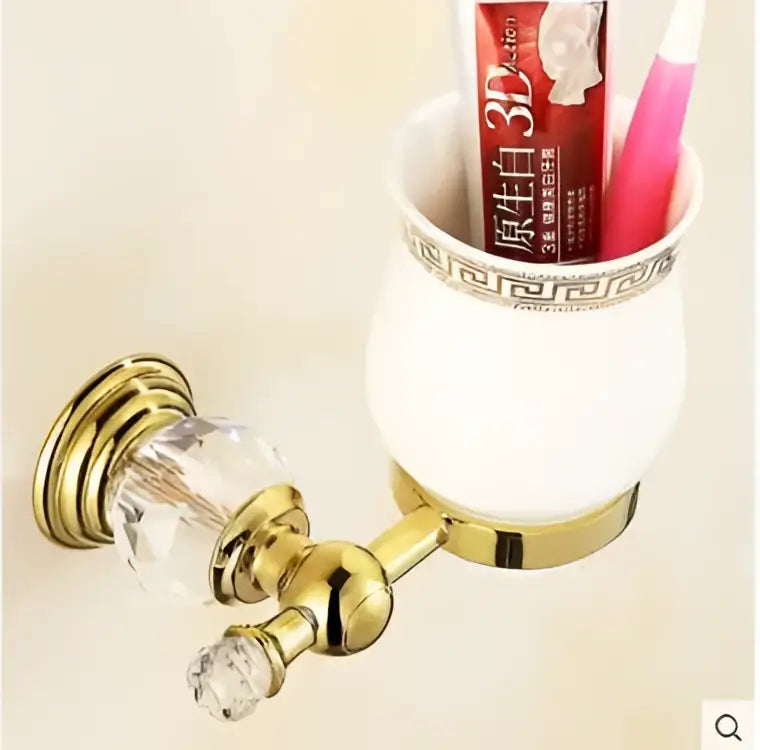 Gold-toned crystal bathroom accessories set with brass toothbrush holder and white ceramic cup with gold greek key rim