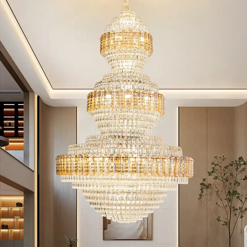 A decorbites crystal duplex chandelier with gold-toned clear crystals in cascading tiers for hotel lobby decor