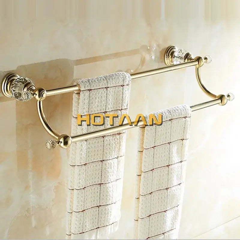 Crystal gold double towel bar with crystal embellishments holding white textured towels for bathroom use