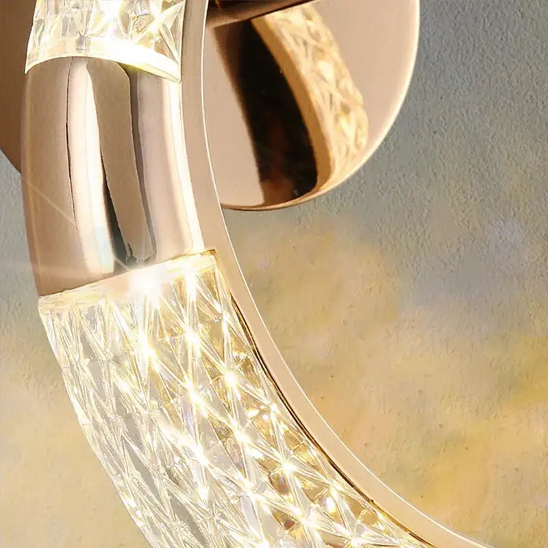 A crystal nordic wall sconce with polished gold metal and faceted crystals for elegant bedroom decorbites lighting