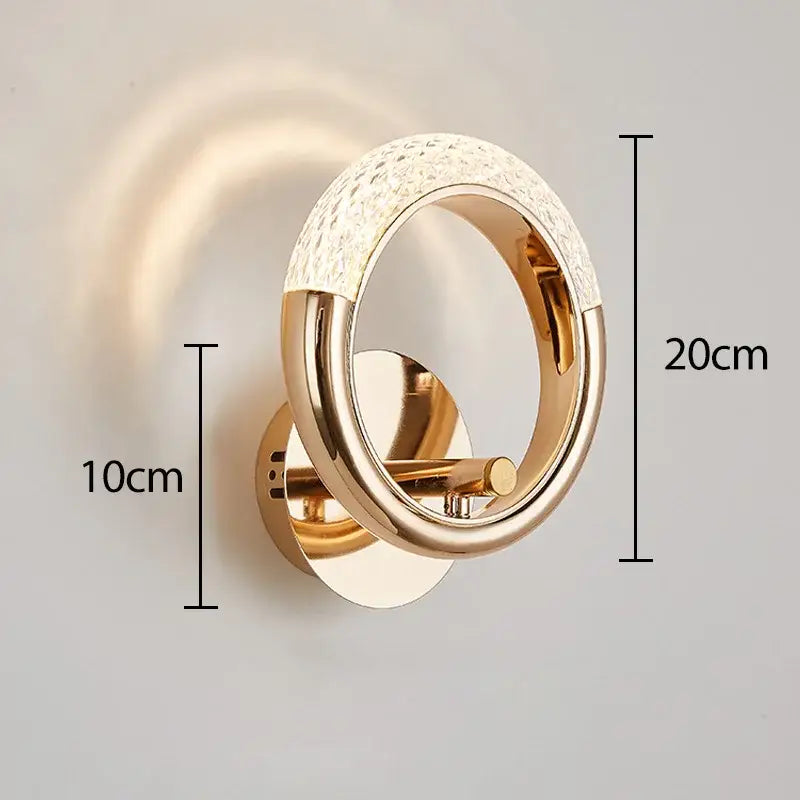 Gold-toned decorbites crystal nordic wall sconce with circular design and sparkling crystal accents for bedroom light