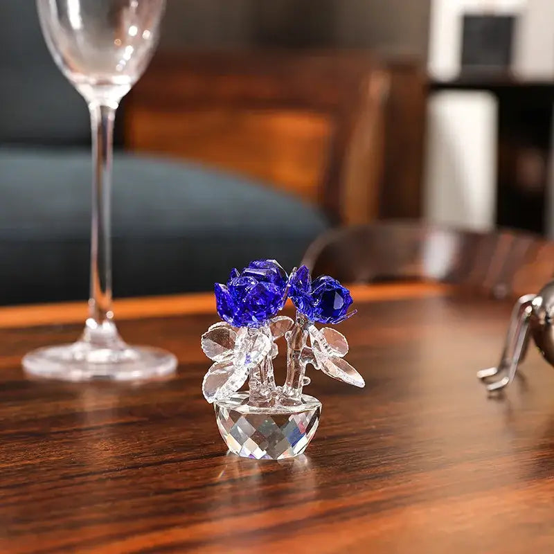 A delicate crystal glass paperweight bouquet with vibrant blue rose flower dreams and clear glass leaves in a vase
