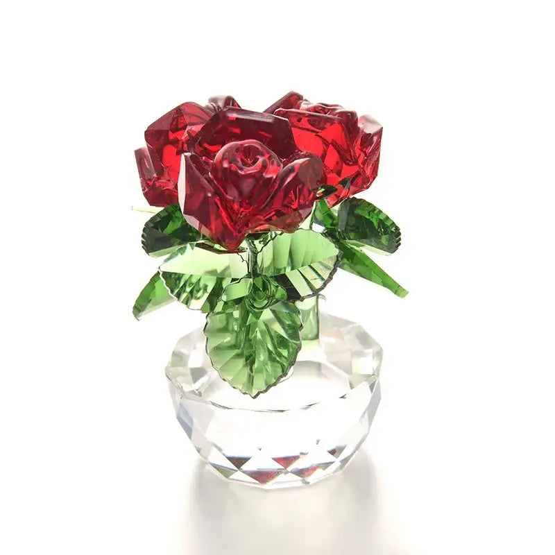 A sparkling red crystal rose flower dreams glass paperweight bouquet with green leaves in a faceted glass vase