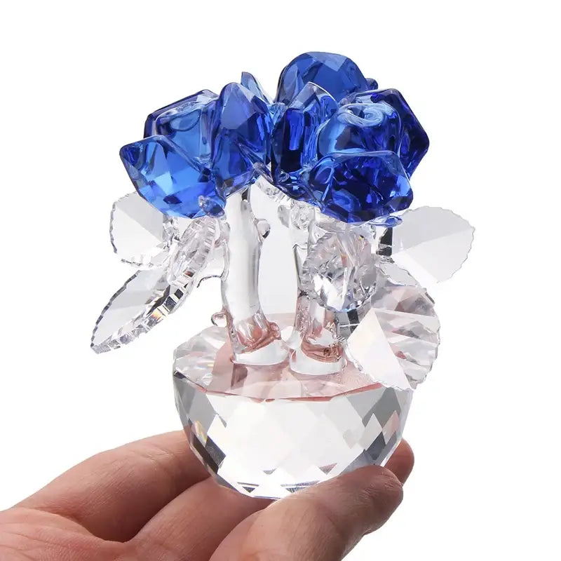 A sparkling blue crystal rose flower dreams glass paperweight bouquet in a clear faceted glass vase for decor