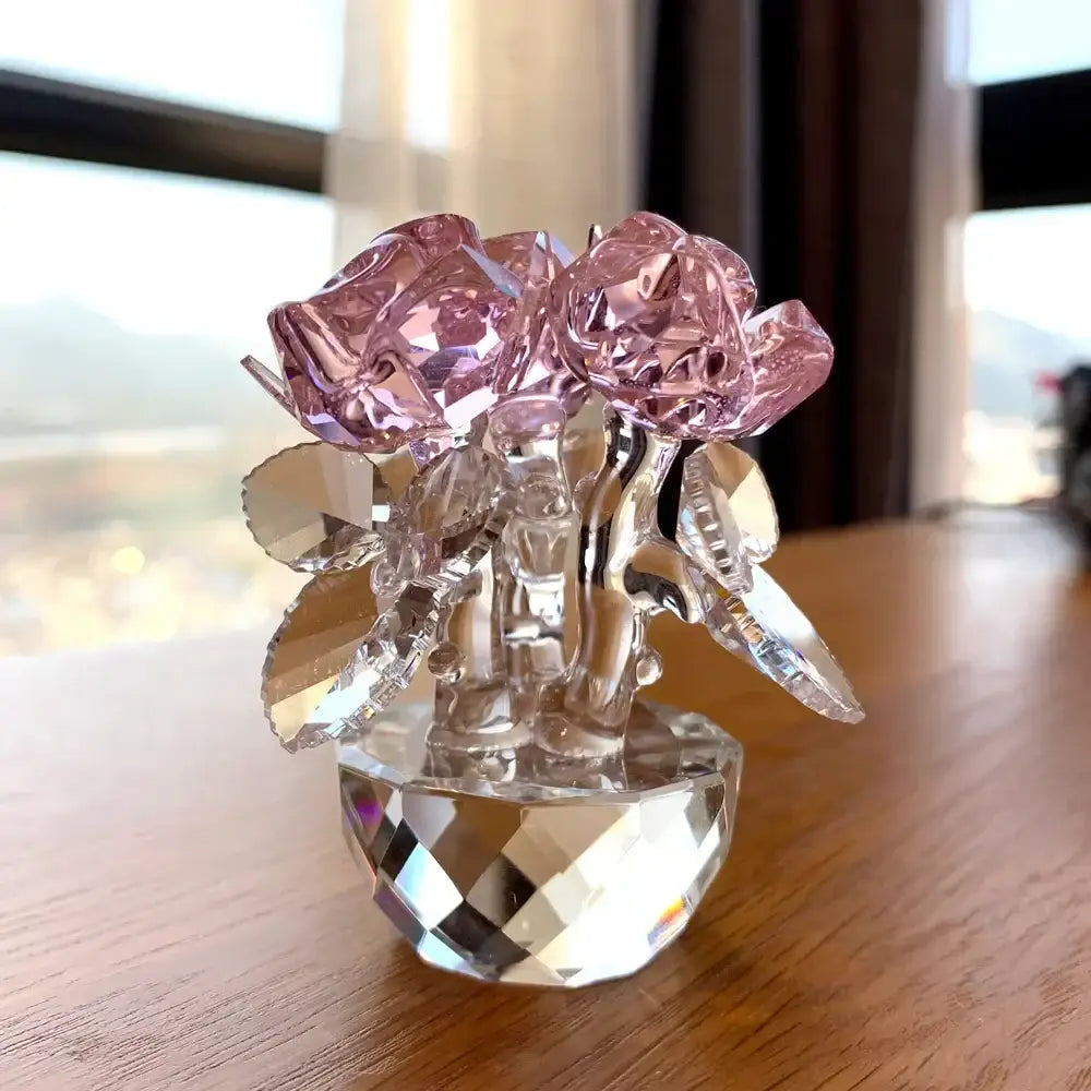 A delicate pink rose flower dreams glass paperweight bouquet with clear faceted leaves and stem in a multifaceted base