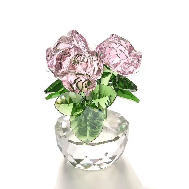 A delicate pink crystal rose flower dreams glass paperweight bouquet with green leaves in a faceted clear vase