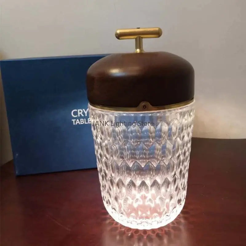 Crystal table lamp with clear diamond-cut glass jar, dark brown wood lid, and brass t-shaped handle for bedroom night light