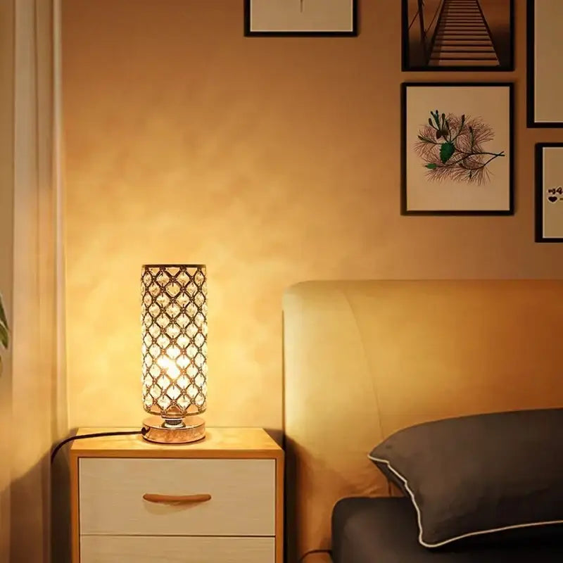 Crystal touch bedside touch bedside lamp with gold-toned metal frame and diamond cutouts emitting warm light