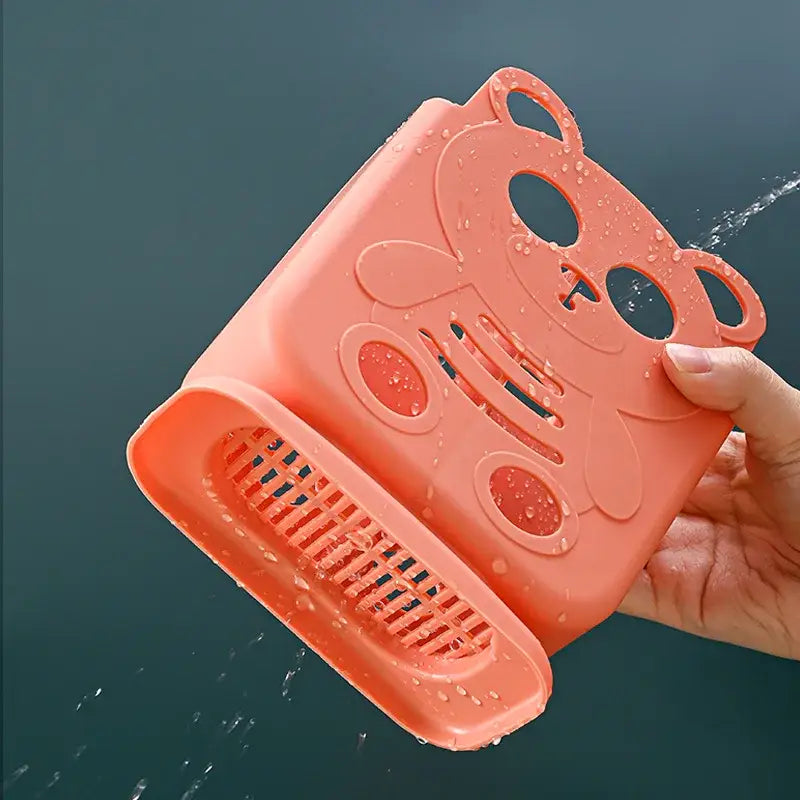 A coral-colored bear-shaped plastic kitchen strainer with a smiling face for decorbites cutlery organizer stand kitchen storage