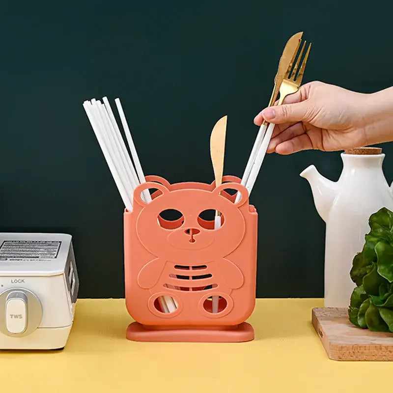 Coralbear-shaped plastic cutlery organizer stand holding white straws and gold knives for kitchen storage decorbites