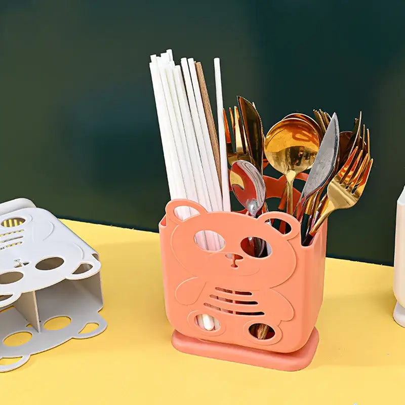Pink plastic bear-shaped decorbites cutlery organizer stand with cutout details for kitchen storage and organization