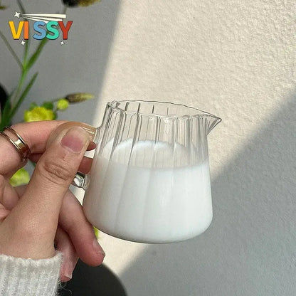 Clear glass pitcher with fluted design filled with white liquid paired with cute bear glass cups ceramic base