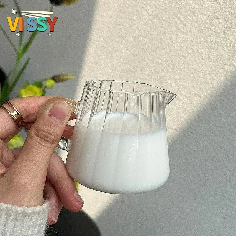 Clear glass pitcher with fluted design filled with white liquid paired with cute bear glass cups ceramic base
