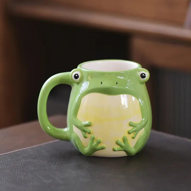 Glossy green cute cartoon animal ceramic mug shaped like a frog with black eyes and yellow underbelly for breakfast