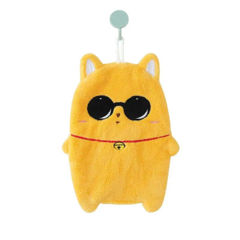 A cute cartoon animal hand towel in thick yellow plush shaped like a cat with embroidered sunglasses and a bell collar
