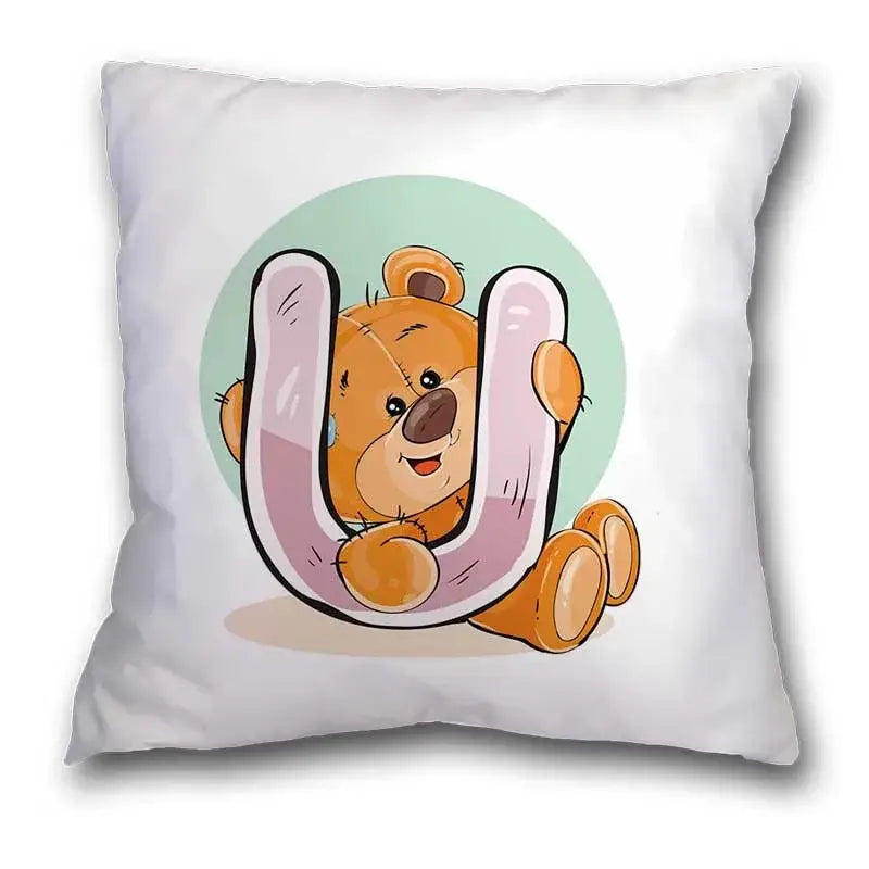 White pillow case featuring a cute cartoon bear animal peeking behind a pink letter u with a light green background