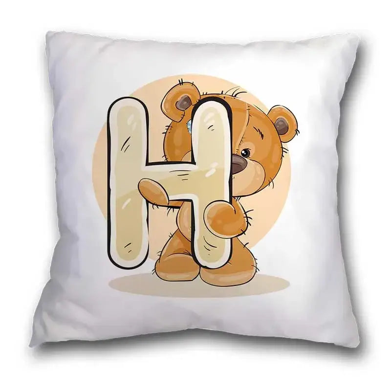 White pillow case featuring a cute cartoon bear animal holding a cream letter h on a soft peach background for bedroom decor