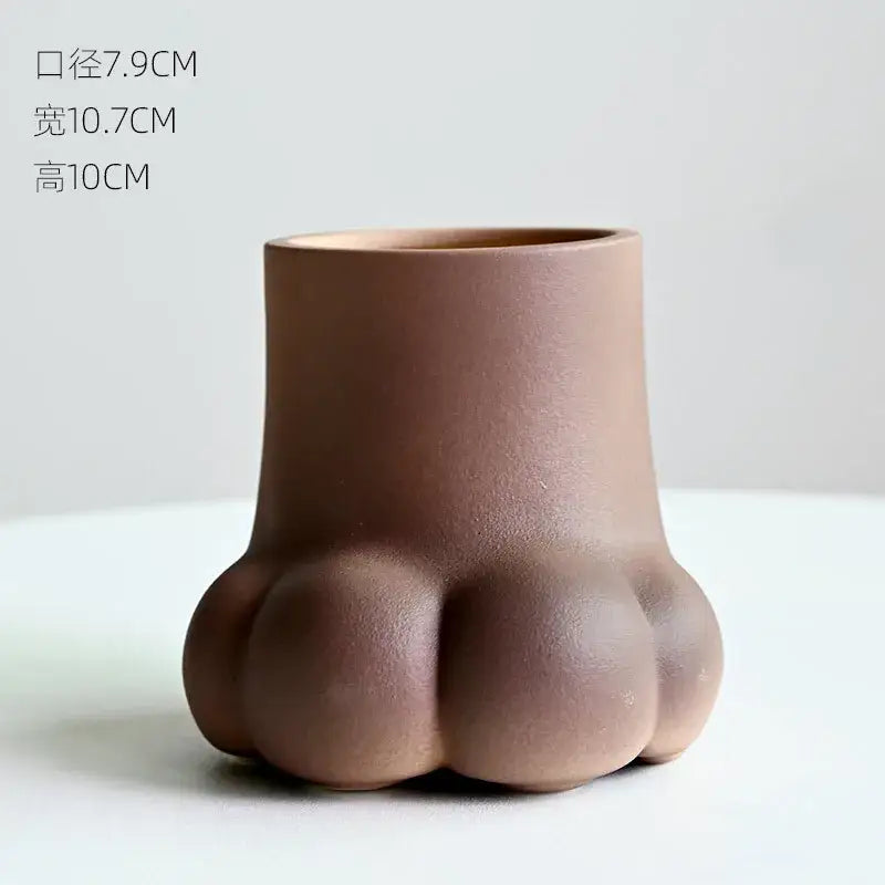 Matte brown ceramic planter shaped like a cute cartoon cat paw with rounded toes for living room decor