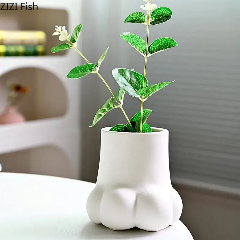 Cute cartoon cat white ceramic paw-shaped planter holding green eucalyptus with small white flowers for living room decor