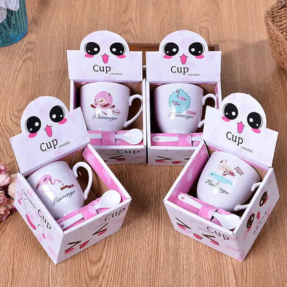 White ceramic cartoon coffee mug set with pink flamingo design and matching pink spoons in cartoon decorbites box