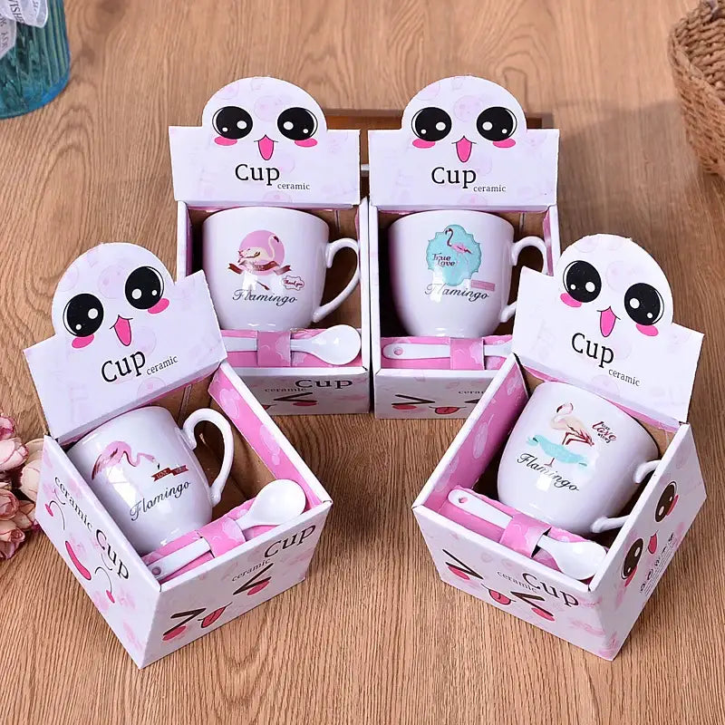 White ceramic cartoon coffee mug set with pink flamingo design and matching pink spoons in cartoon decorbites box