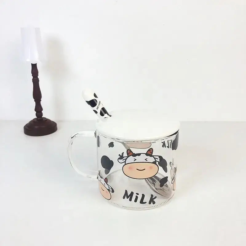 Clear glass mug with white spoon lid and black-and-white cow pattern glass design featuring the word milk