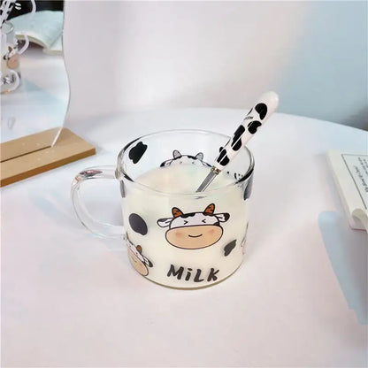 Clear glass mug with black and white cow pattern glass design and spoon lid featuring a cartoon cow and milk text