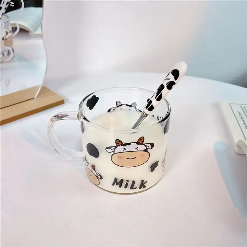 Clear glass mug with black and white cow pattern glass design and spoon lid featuring a cartoon cow and milk text