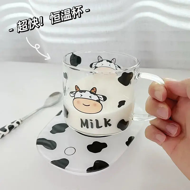 Clear glass mug with black cow pattern and milk text featuring a cartoon cow face and spoon lid for dining room use