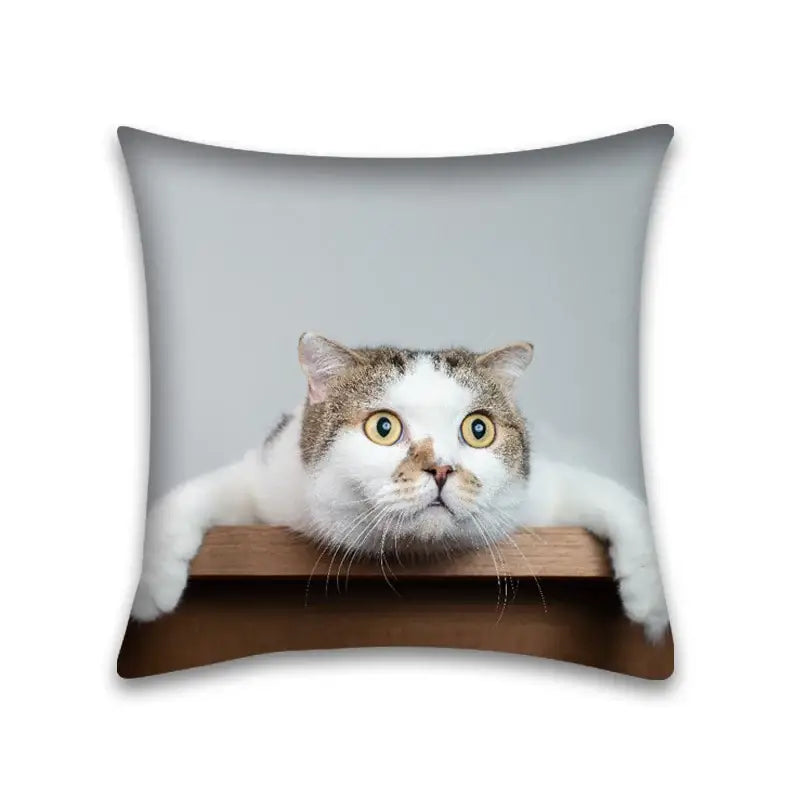 Square pillow case with a cute cat anime design of a white and brown tabby cat with yellow eyes on wood surface