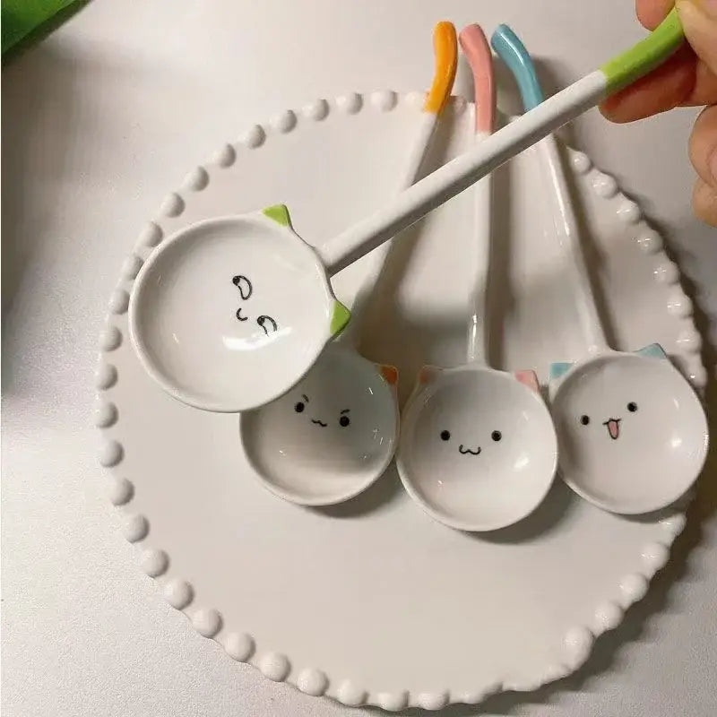 Set of four cute cat ceramic spoons with white ceramic faces and pastel colorful handles for kitchen and dining use
