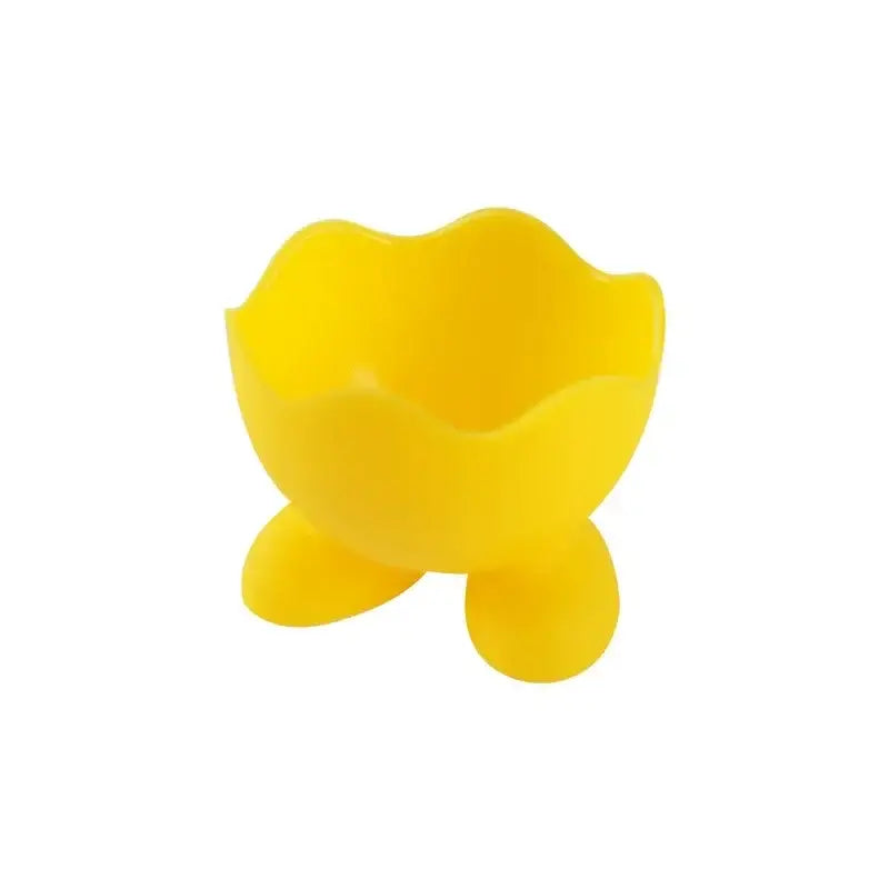 Bright yellow silicone egg cup holder with scalloped rim and three rounded feet for kitchen breakfast use