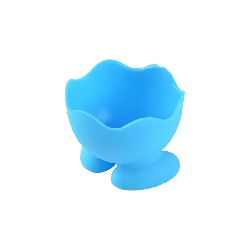 Bright blue silicone egg cup holder with scalloped rim and three suction cup feet for kitchen breakfast use