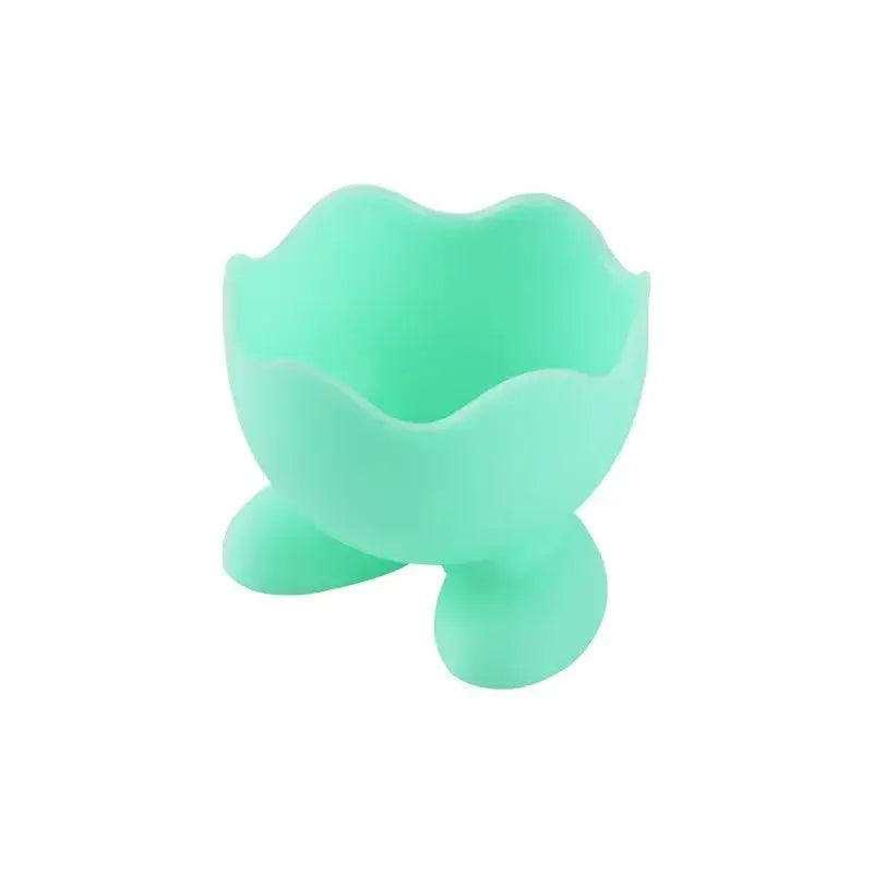Mint green silicone egg cup holder with scalloped rim and three rounded feet for kitchen breakfast use