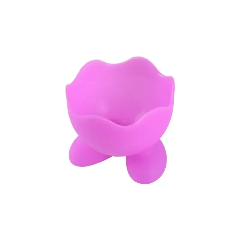 Pink silicone egg cup holder with flower-shaped rim and three rounded feet for kitchen breakfast use